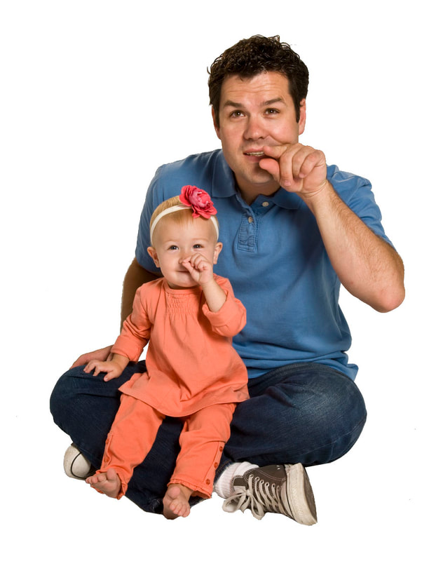 photo of young child doing hand signs with adult man
